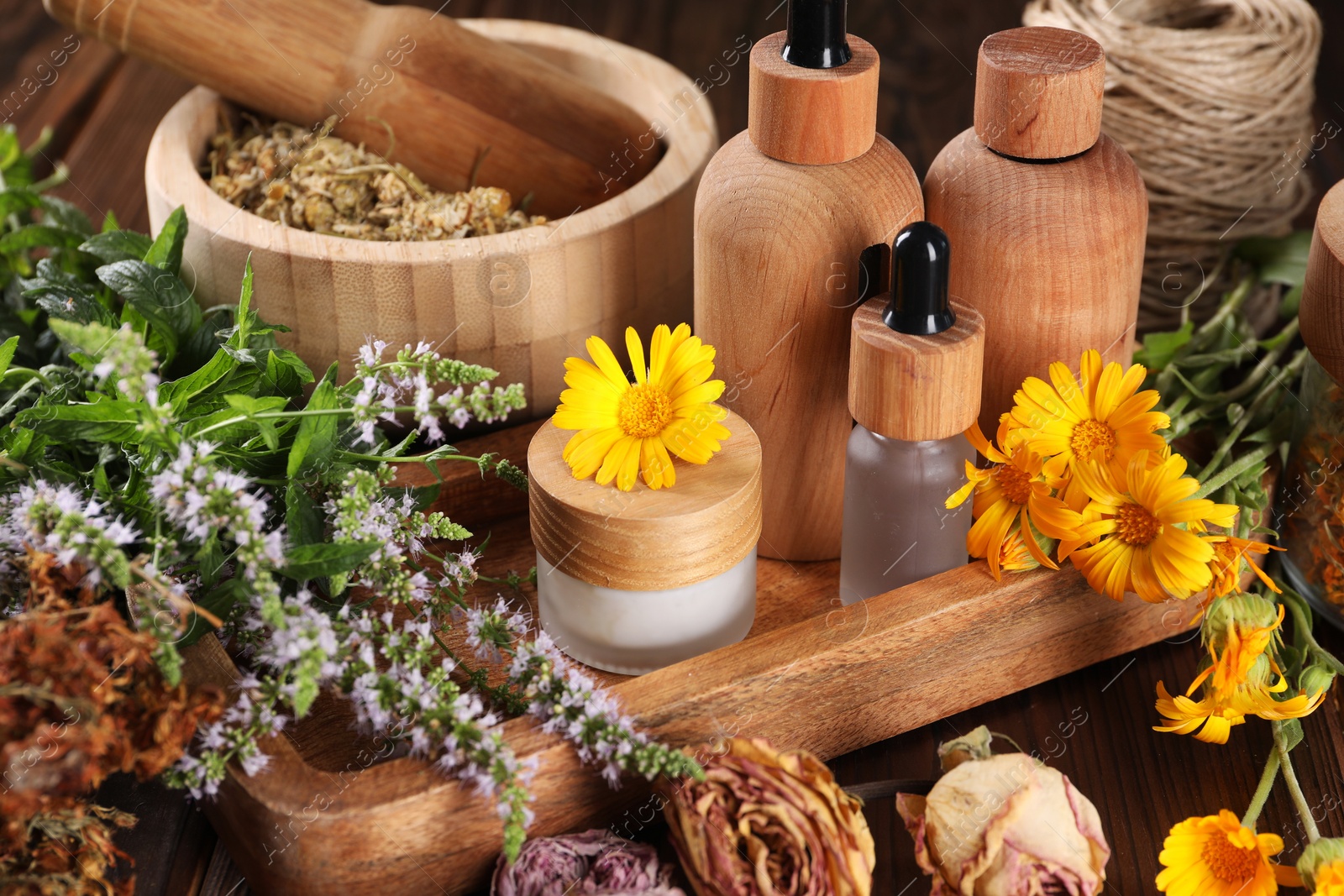 Photo of Jar, bottles of essential oils and different herbs on wooden table