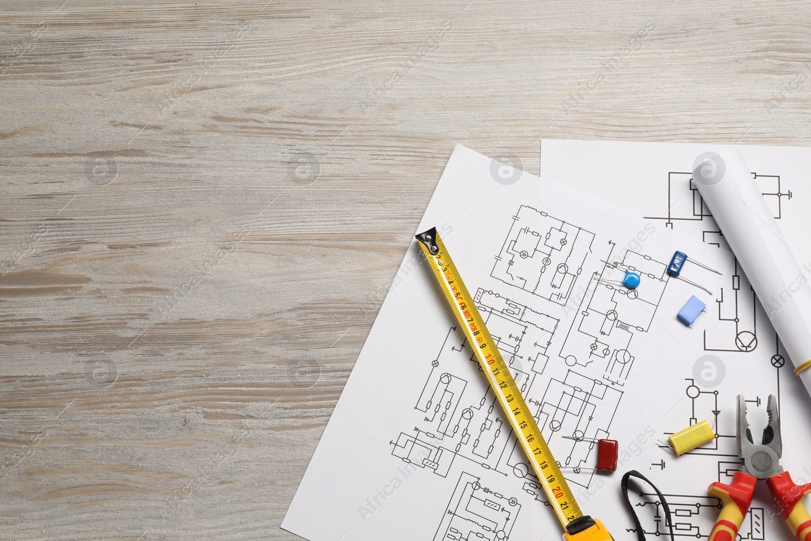 Photo of Wiring diagrams and tools on white wooden table, flat lay. Space for text