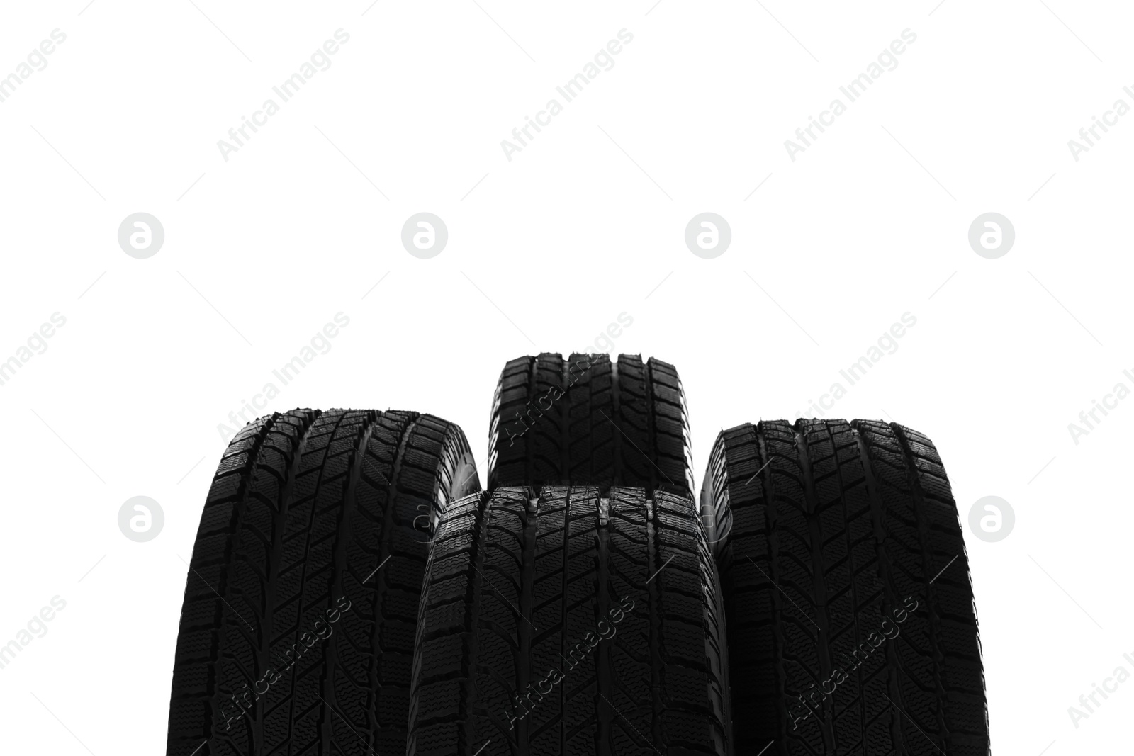 Photo of Set of new winter tires on white background, closeup