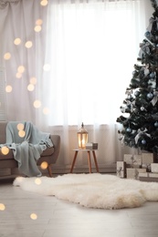 Stylish living room interior with decorated Christmas tree and blurred lights in foreground