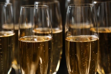 Many glasses of champagne as background, closeup view