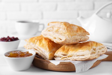 Photo of Delicious puff pastry served on white wooden table, closeup