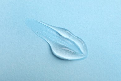 Photo of Swatch of cosmetic gel on light blue background, top view