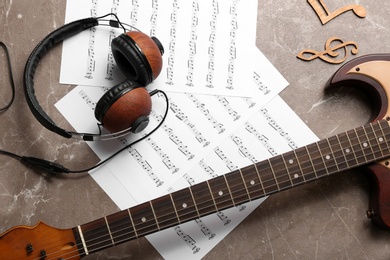 Photo of Flat lay composition with music notes, headphones and guitar on color background