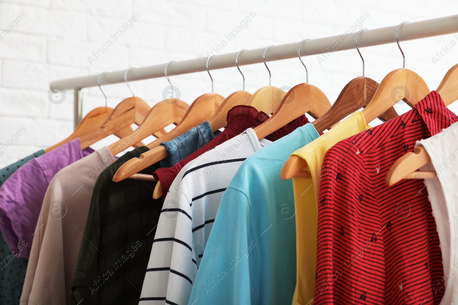 Photo of Wardrobe rack with stylish clothes on white background, closeup