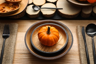 Photo of Autumn table setting with pumpkin on wooden background