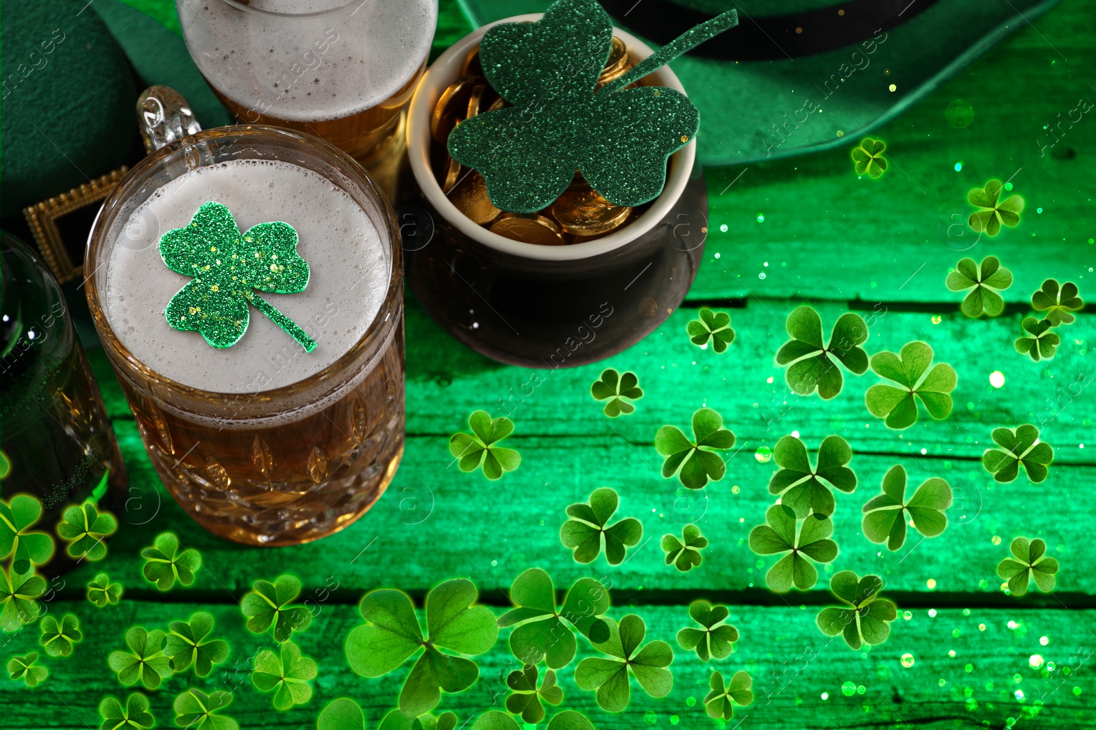 Image of St. Patrick's day. Beer, leprechaun pot of gold and decorative clover leaves on green wooden table, above view. Space for text