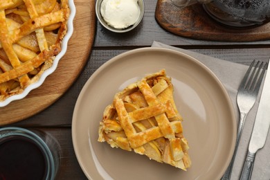 Photo of Tasty homemade quince pie served on wooden table, flat lay