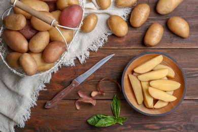 Photo of Flat lay composition with fresh organic potatoes on wooden background