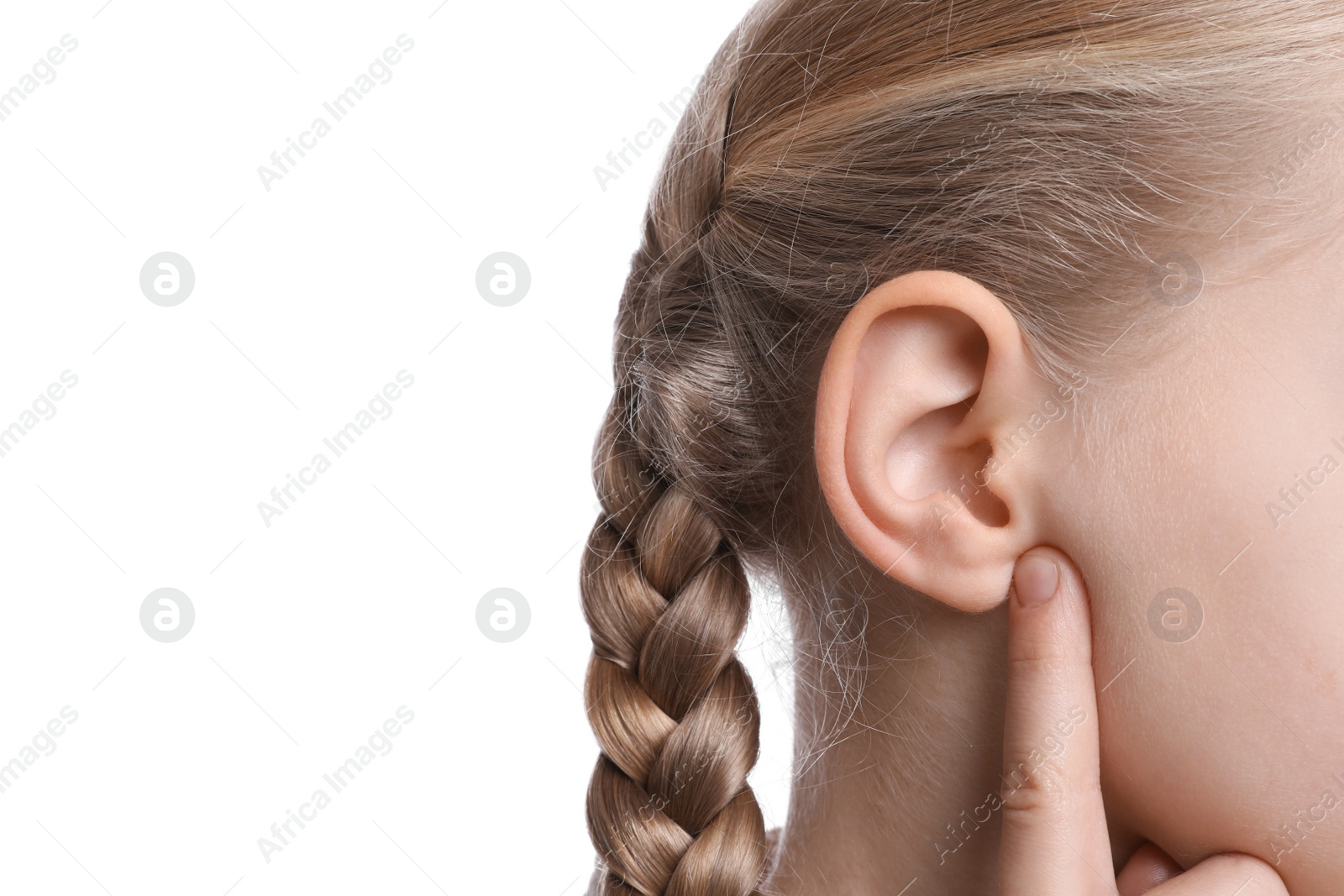 Photo of Cute little girl pointing at her ear on white background, closeup