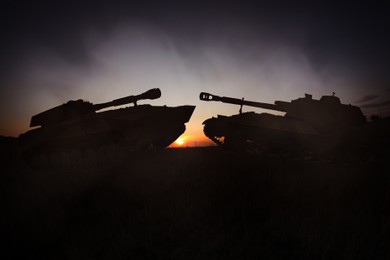 Silhouettes of tanks on battlefield in night