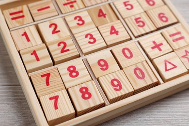 Photo of Math game with numbers on white wooden table, closeup