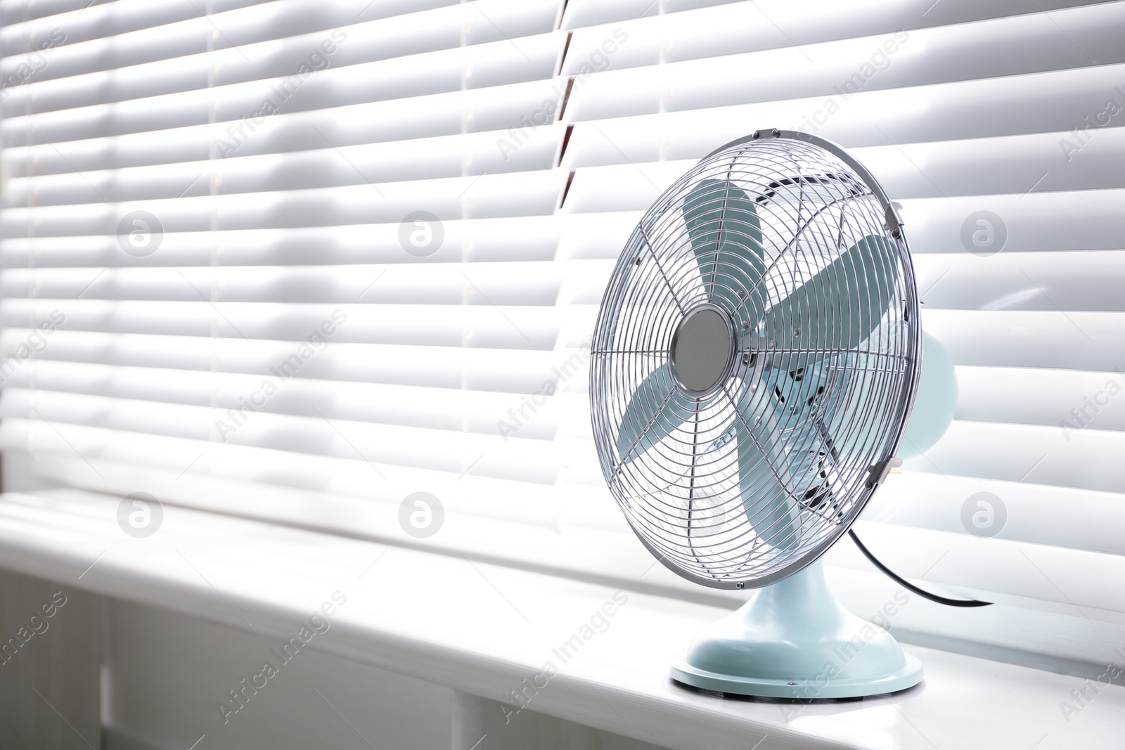 Photo of Modern electric fan on window sill indoors. Space for text