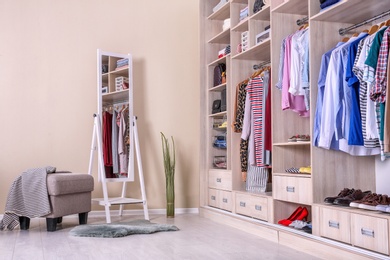 Photo of Large wardrobe with different clothes and shoes