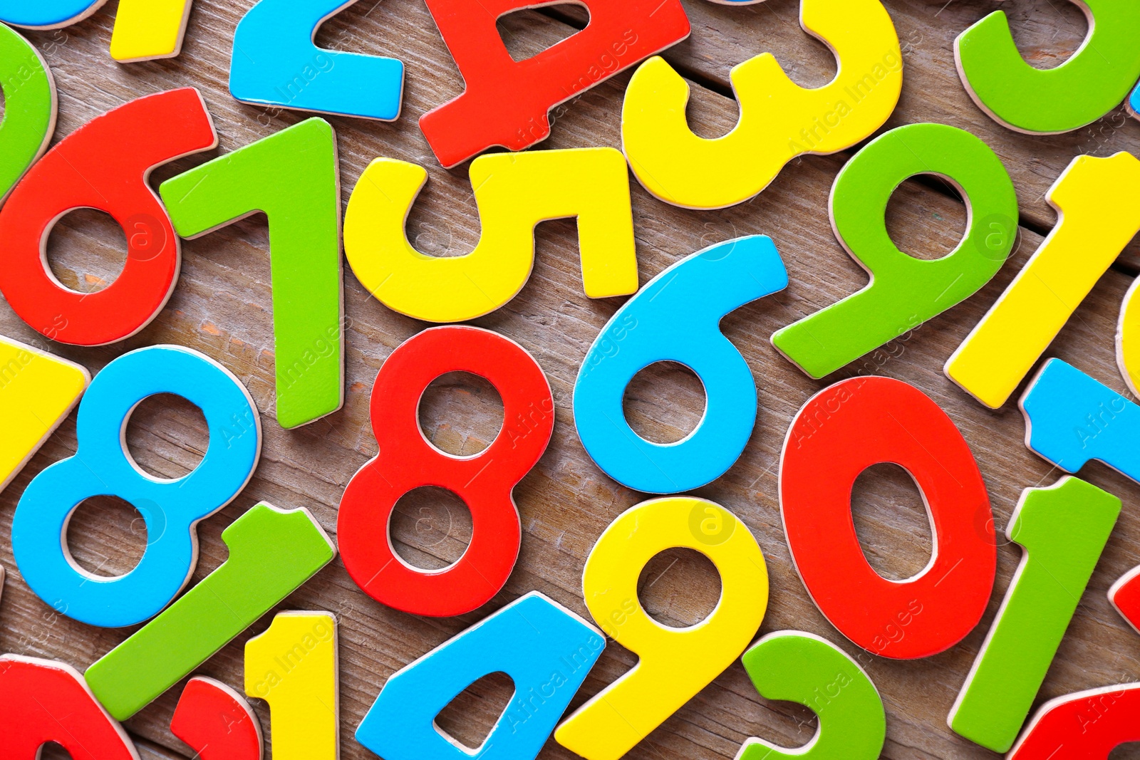 Photo of Colorful numbers on wooden table, flat lay