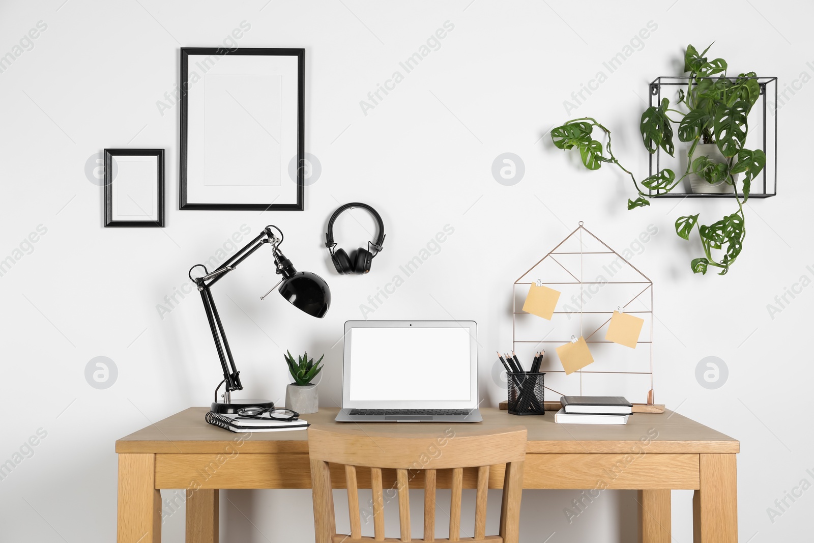 Photo of Home workplace. Laptop, lamp and stationery on wooden desk