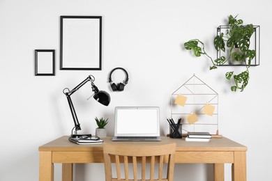 Home workplace. Laptop, lamp and stationery on wooden desk