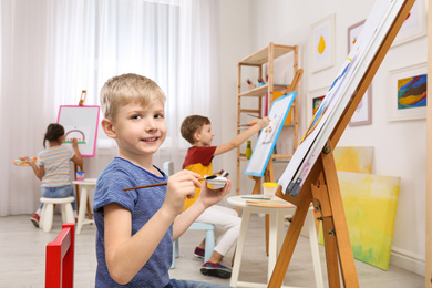 Photo of Cute little children painting during lesson in room