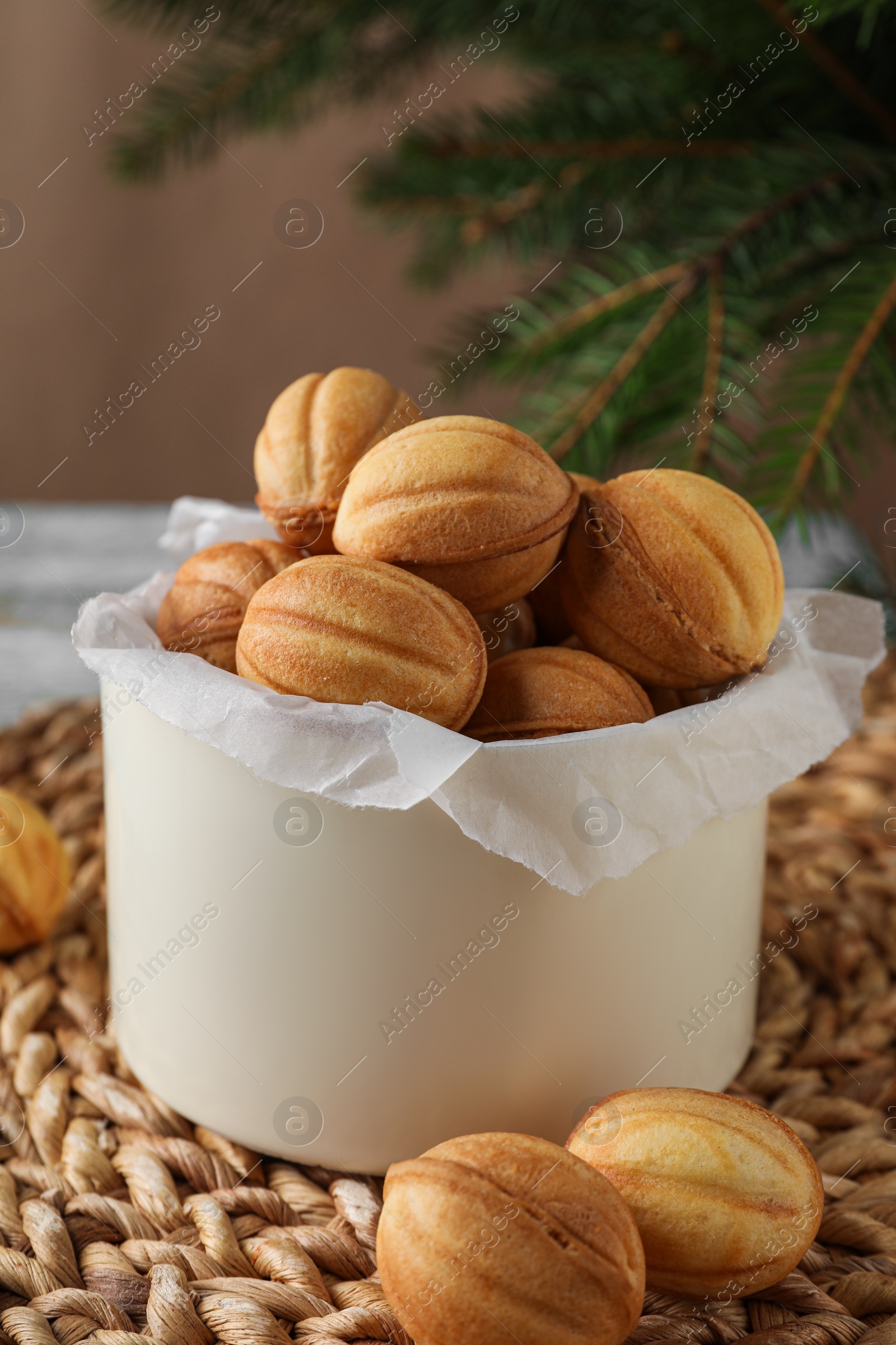 Photo of Delicious nut shaped cookies on wicker mat, closeup