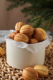 Delicious nut shaped cookies on wicker mat, closeup