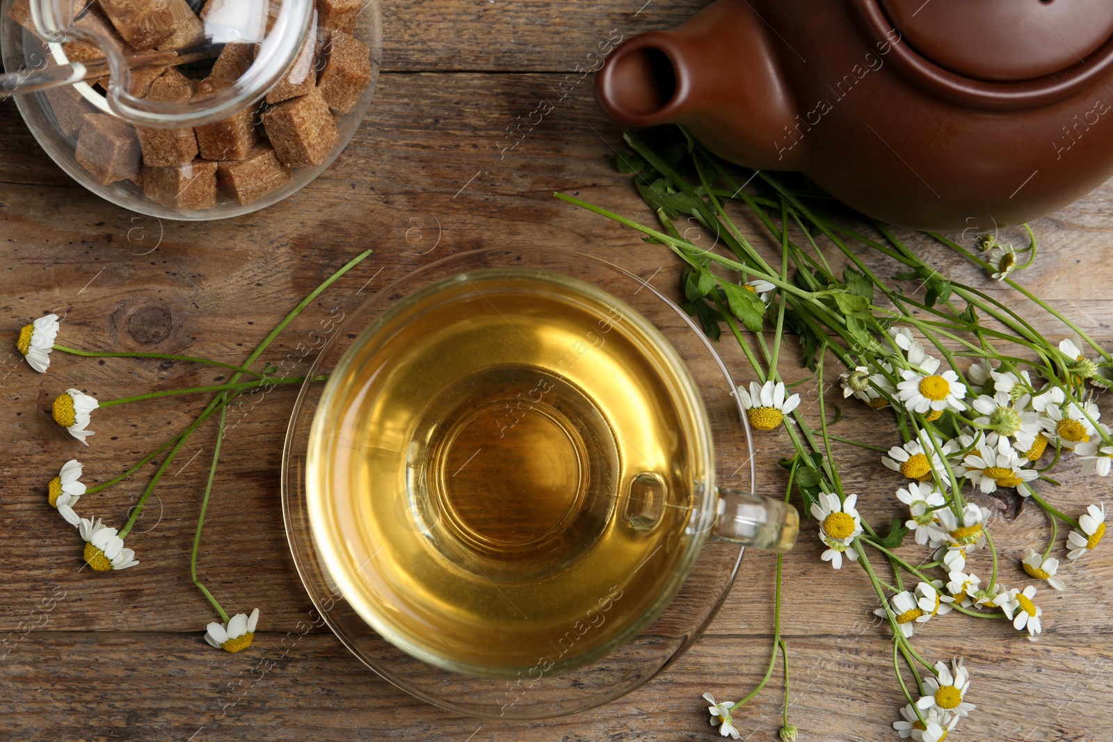 Photo of Flat lay composition with tea and chamomile flowers on wooden table