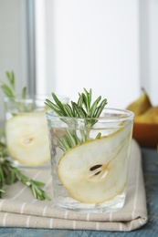 Refreshing pear cocktail with rosemary on table