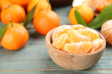 Photo of Fresh tangerine slices on blue wooden table, closeup. Space for text