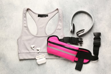 Flat lay composition with pink waist bag on light grey table