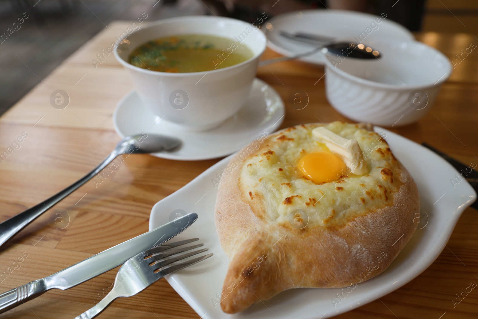 Photo of Fresh delicious Adjarian khachapuri with cheese and egg on wooden table