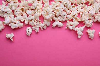 Photo of Tasty popcorn on pink background, flat lay. Space for text