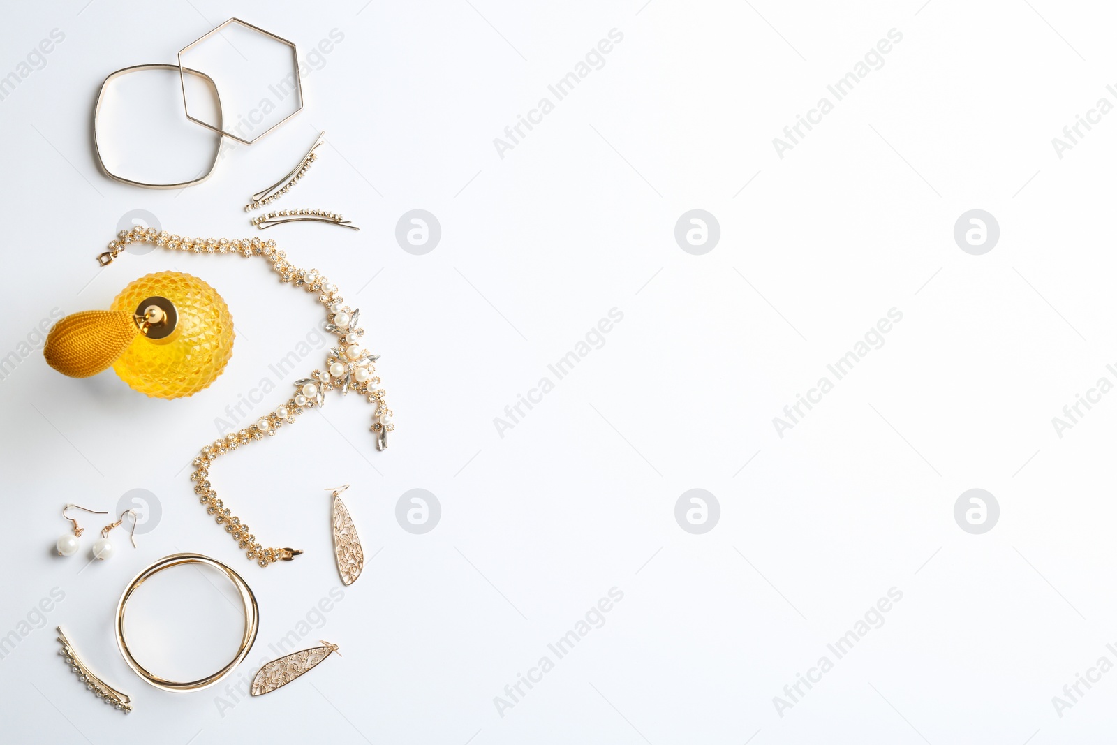 Photo of Composition with perfume bottle and jewellery on white background, top view