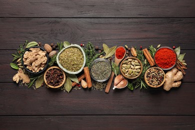 Different natural spices and herbs on wooden table, flat lay