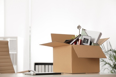 Cardboard box full of stuff on table in office