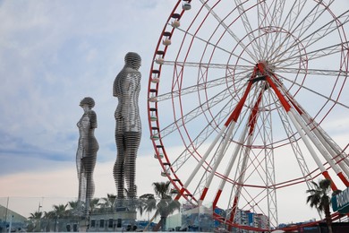 Photo of BATUMI, GEORGIA - MAY 31, 2022: Movable sculptural composition Ali and Nino near Ferris wheel