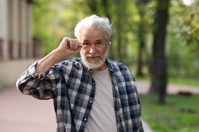 Portrait of happy grandpa with glasses in park