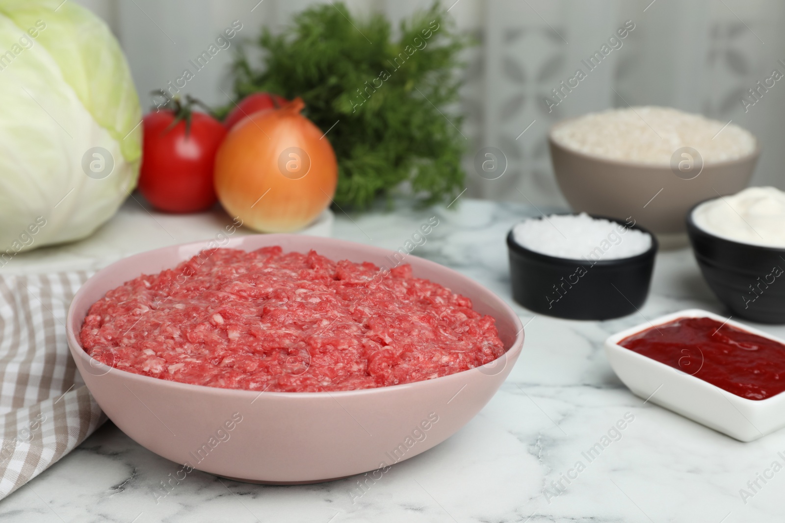 Photo of Set of ingredients for preparing stuffed cabbage rolls on white marble table