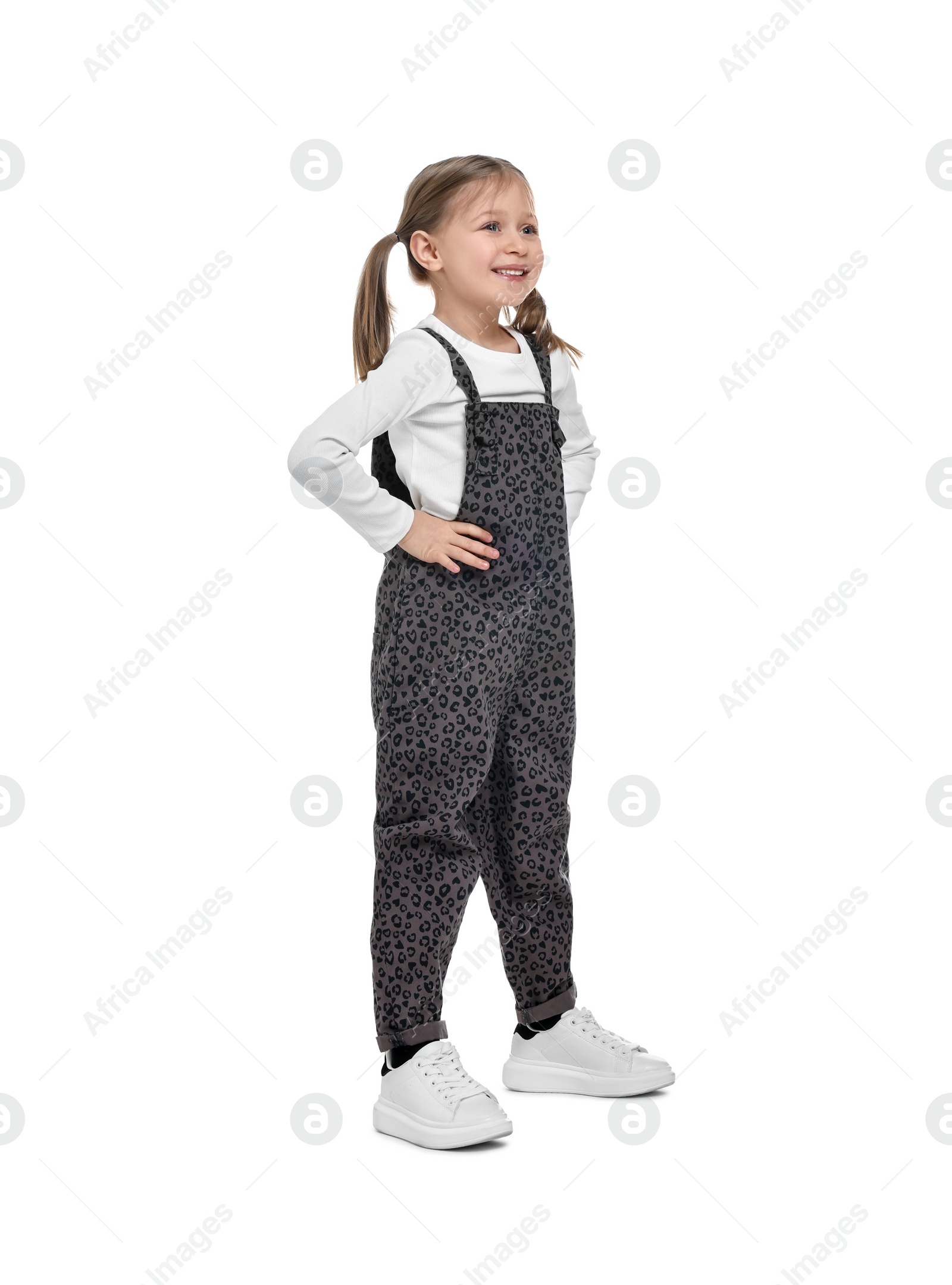 Photo of Cute girl in stylish overall on white background