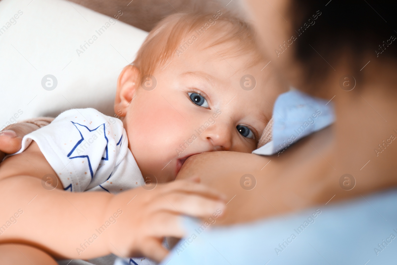 Photo of Young woman breast feeding her little baby, closeup