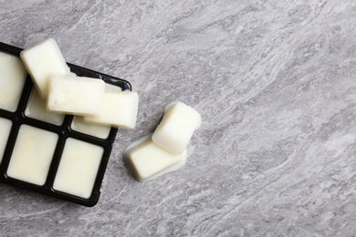 Photo of Ice cubes made with milk and tray on grey background, top view. Space for text