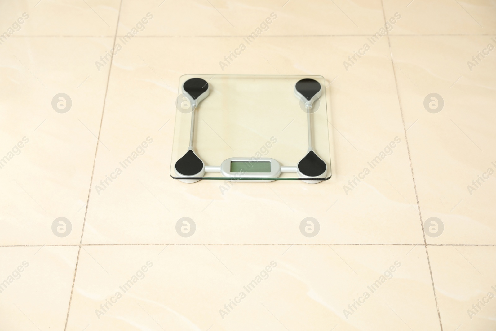 Photo of Scales on tiled floor. Overweight problem