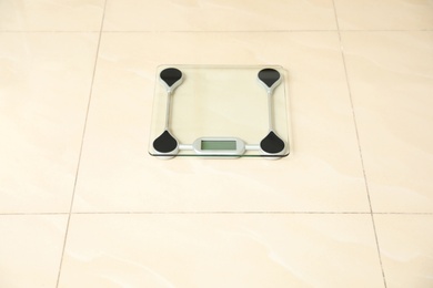 Scales on tiled floor. Overweight problem