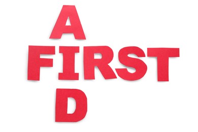 Photo of Words First Aid made of red letters isolated on white, top view