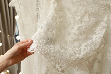 Young woman choosing wedding dress in salon, closeup