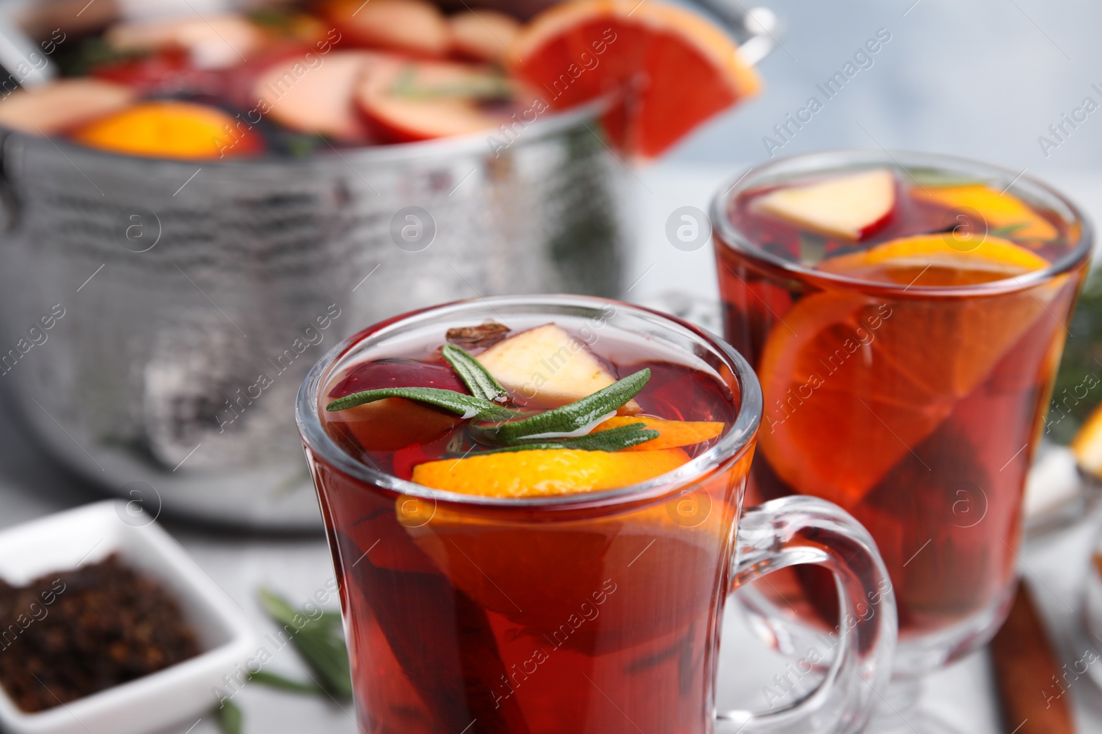 Photo of Tasty mulled wine with spices on table, closeup