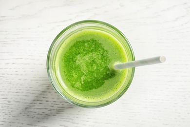 Glass with delicious detox juice on light background, top view