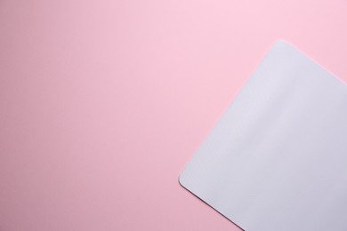 Photo of One mouse pad on pink background, top view. Space for text