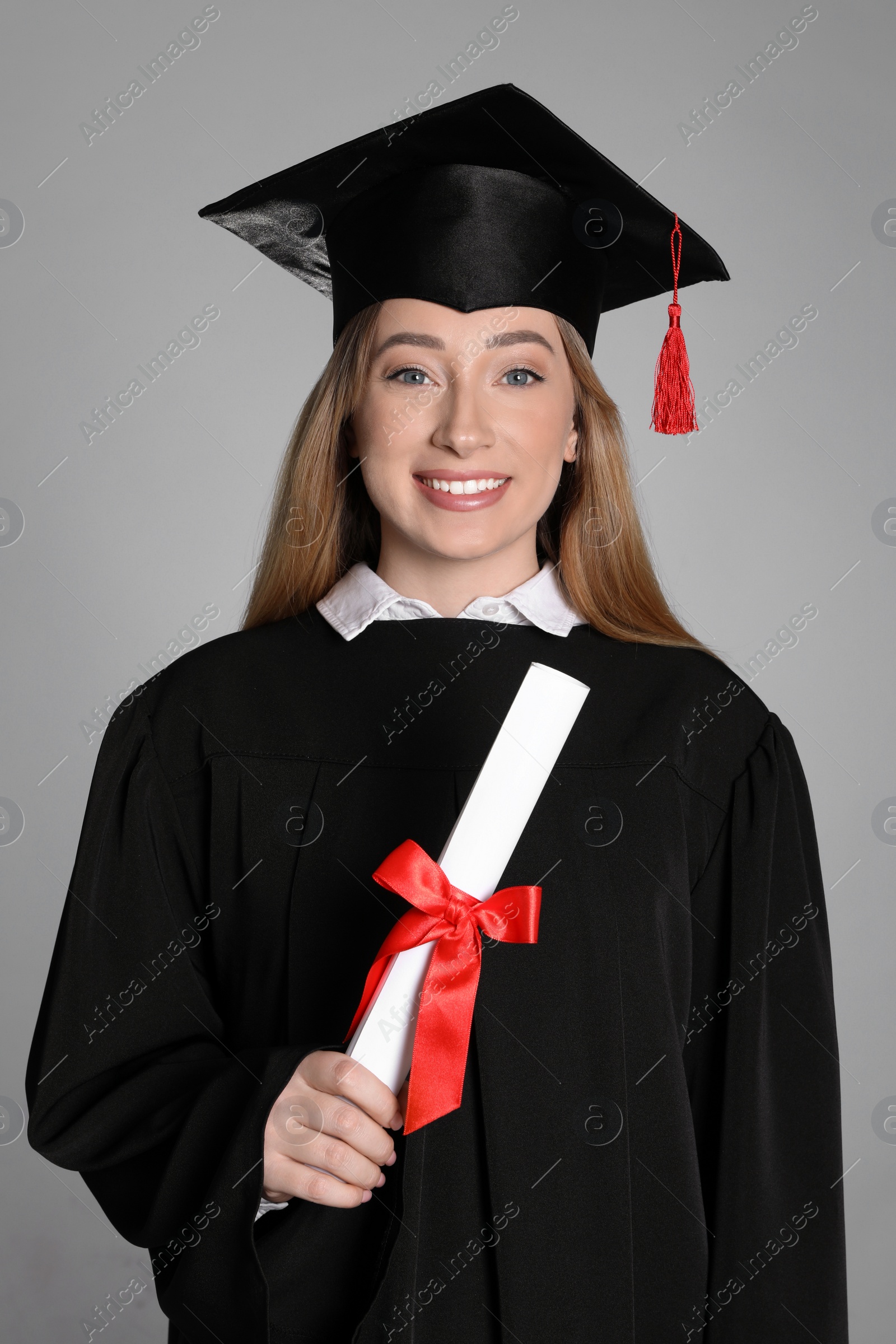 Photo of Happy student with diploma on grey background