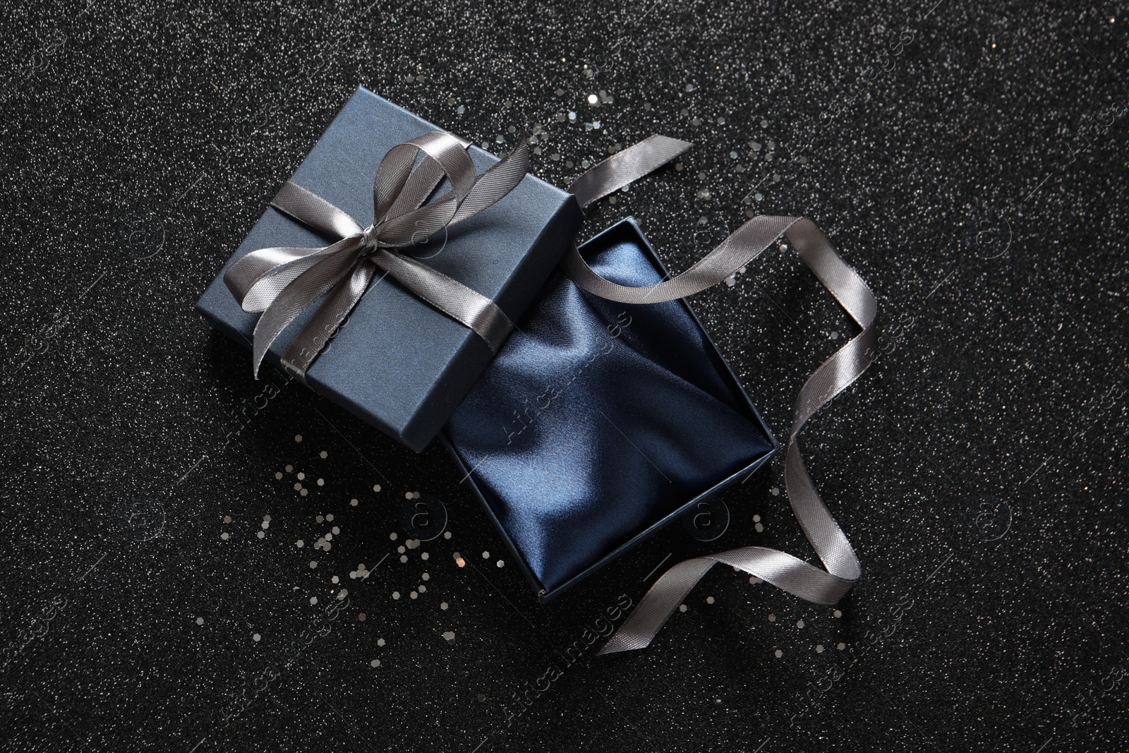 Photo of Open gift box on dark background, top view