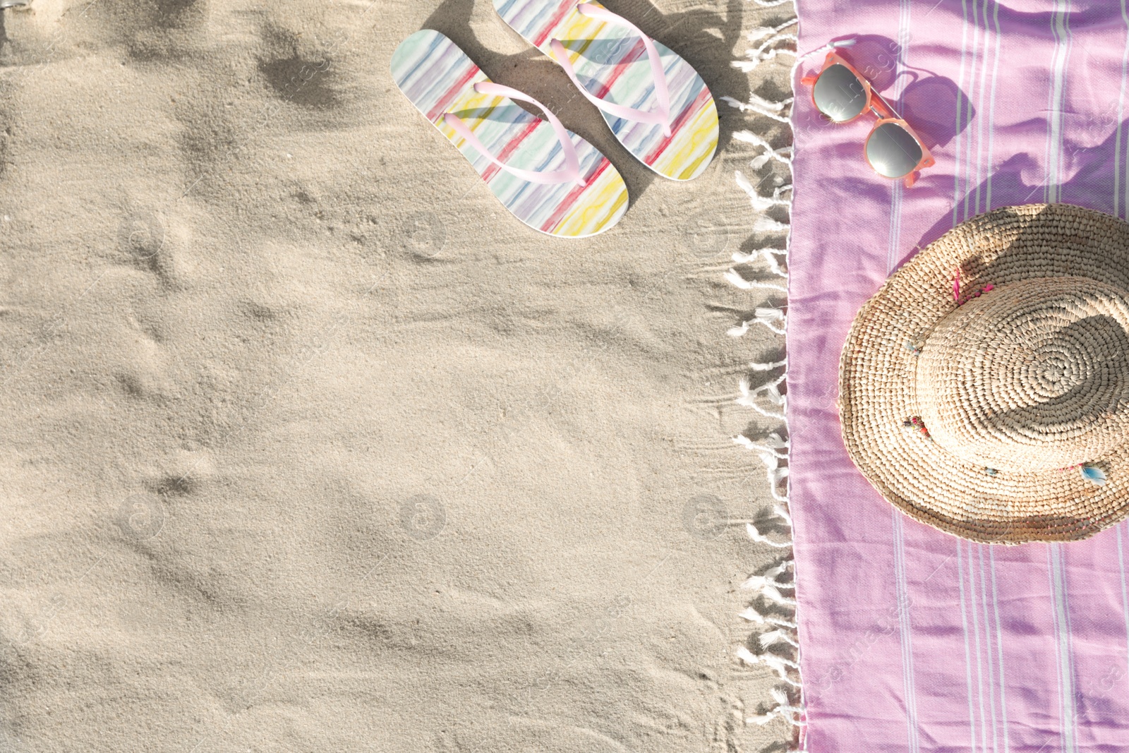 Photo of Flat lay composition with beach accessories on sand. Space for text