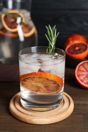 Photo of Delicious refreshing drink with sicilian orange and rosemary on wooden table